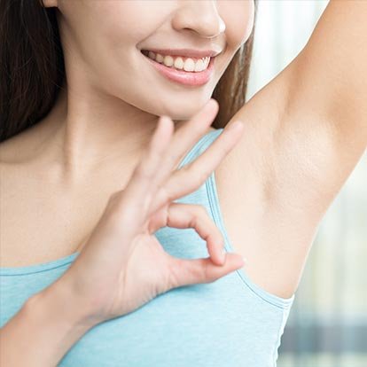 Uśmiechnięta kobieta po zastosowaniu antyperspirantu dla kobiet