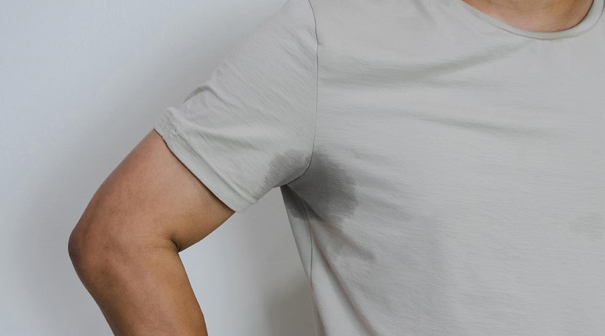 Mężczyzna z problemem nadpotliwości, który nie zastosował dobrego męskiego antyperspirantu