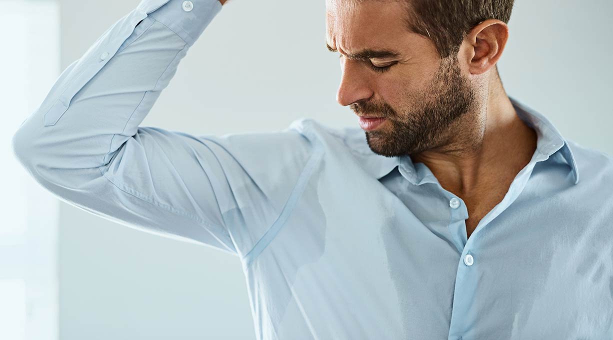 Mężczyzna z problemem nadpotliwości, który nie zastosował dobrego antyperspirantu dla mężczyzn