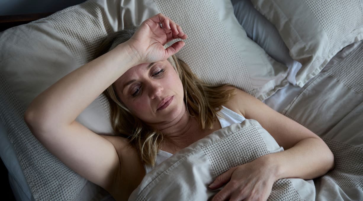 Kobieta zmagająca się z nocnymi potami w czasie menopauzy