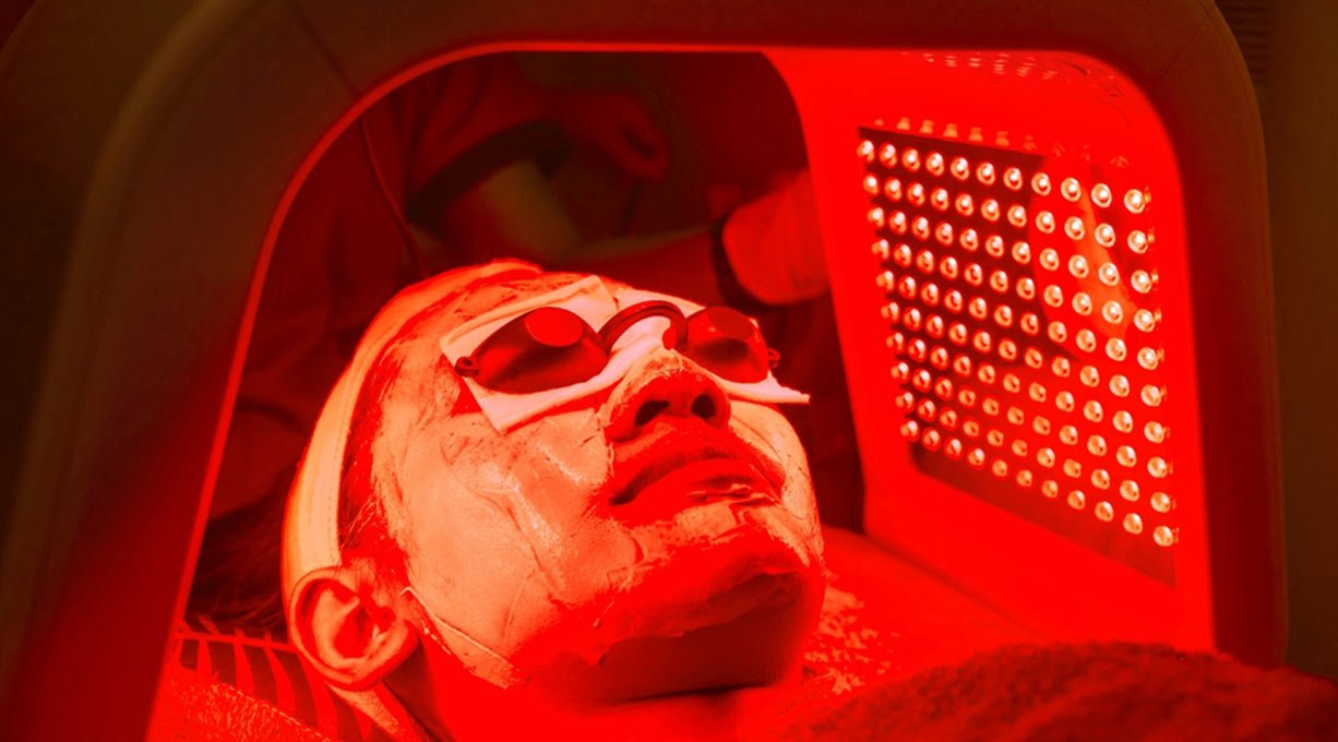 Kobieta leżąca z twarzą pod lampą LED