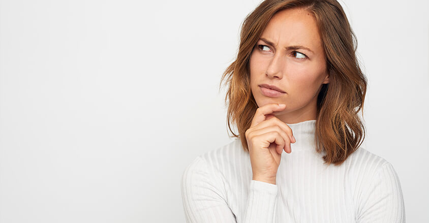 Kobieta zastanawiająca się co wybrać, antyperspirant czy dezodorant