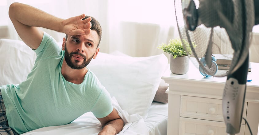 Niewyspany mężczyzna nadmiernie pocący się w nocy