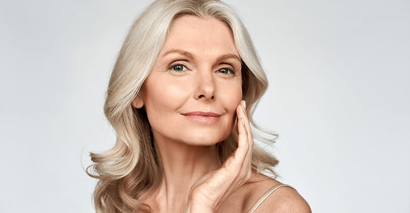 Uśmiechnięta kobieta u której zmarszczki nosowo-wargowe są mniej widoczne