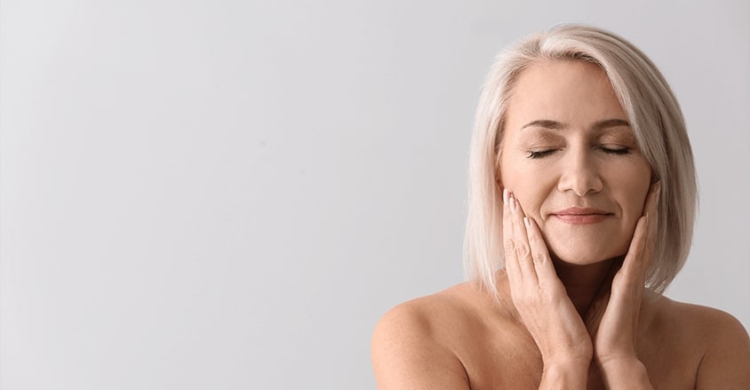 Kobieta stosująca odpowiednią pielęgnację na bruzdy nosowo-wargowe