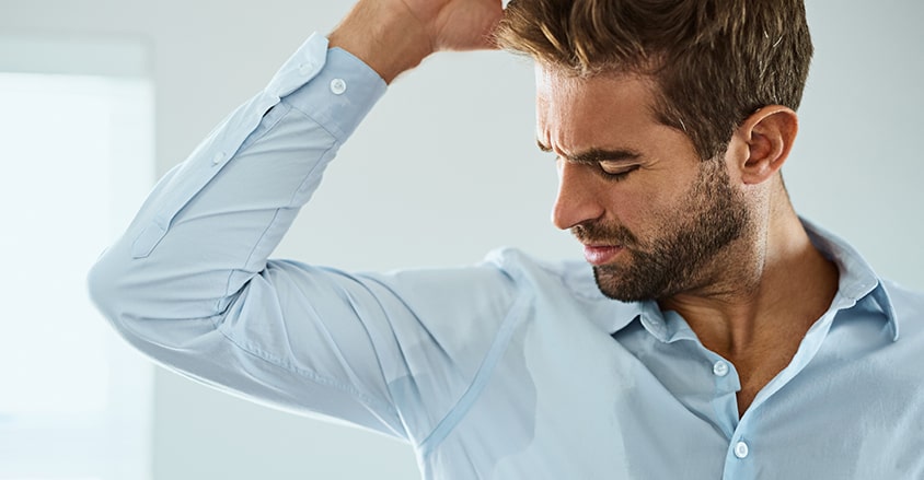 Mężczyzna z problemem nadpotliwości, który nie zastosował dobrego antyperspirantu dla mężczyzn