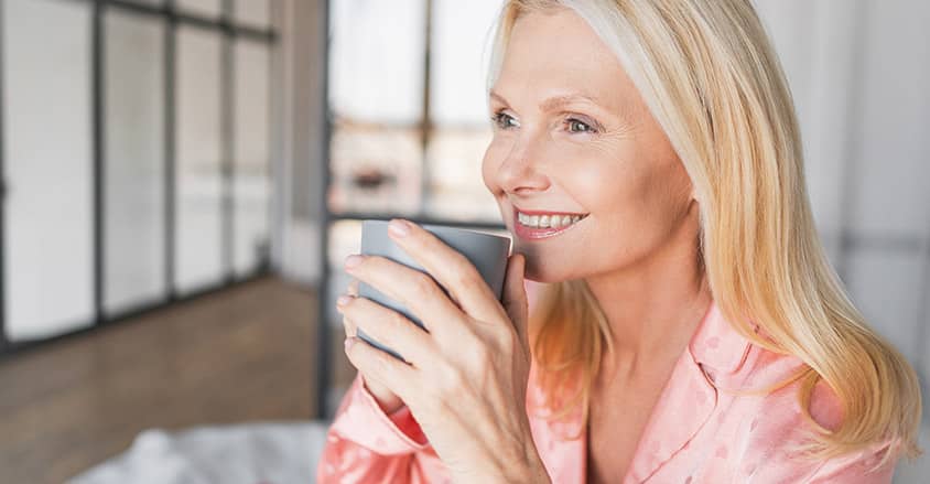 Dojrzała blondynka z kubkiem kawy