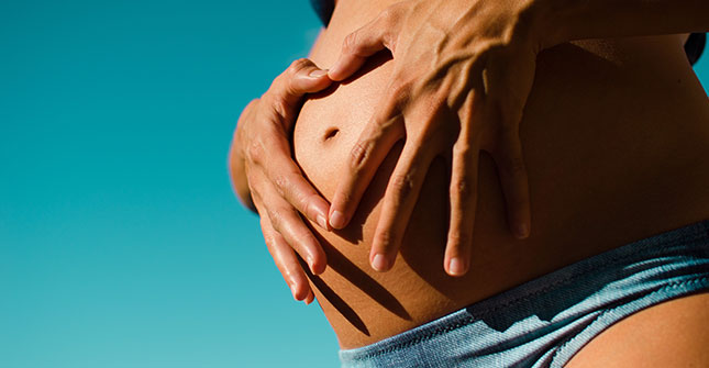Brzuch kobiety w ciąży. Czy opalanie w ciąży jest bezpieczne - Vichy. 