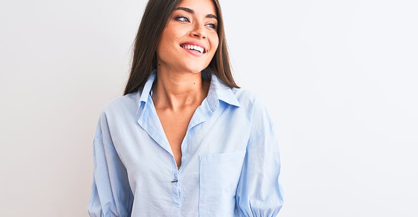 Zadowolona kobieta w jasnej koszuli bez żółtych plam pod pachami