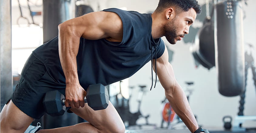 Mężczyzna ćwiczący na siłowni po użyciu dobrego antyperspirantu męskiego