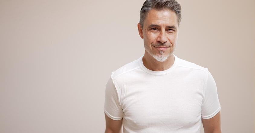 Mężczyzna zastanawiający się, jaki męski krem przeciwzmarszczkowy wybrać