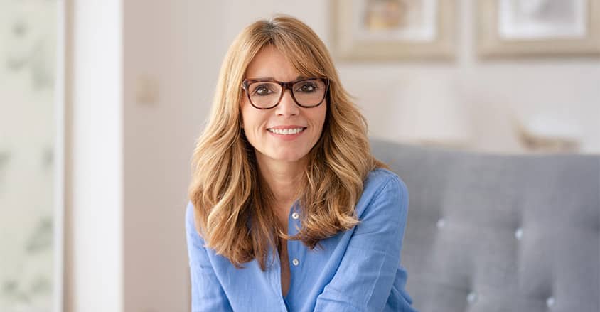 Uśmiechnięta dojrzała kobieta w okularach.